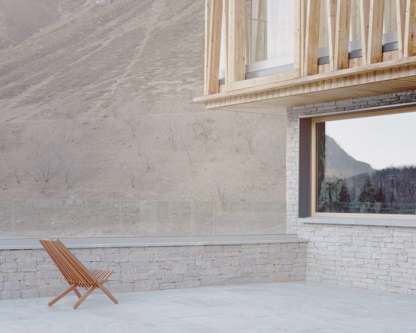 The exterior of a stone and wood-clad chalet by LCA Architetti