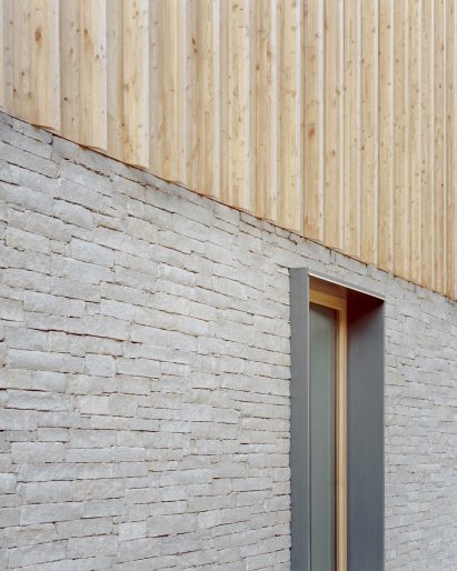 A stone and wood facade of an Italian chalet by LCA Architetti