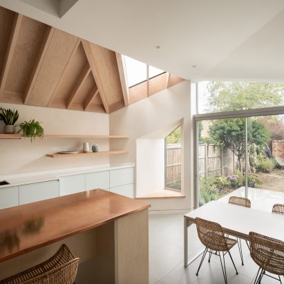 A residential kitchen with an exposed timber ceiling and duck-egg blue cabinetry