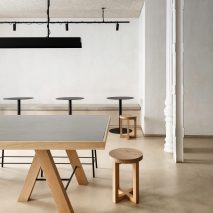 Informal dining area of Zuppa restaurant by Plantea Estudio with wood and steel furniture and floors made of plywood covered in micro-cement