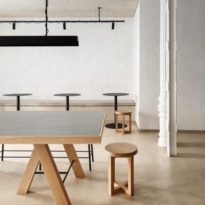 Informal dining area of Zuppa restaurant by Plantea Estudio with wood and steel furniture and floors made of plywood covered in micro-cement