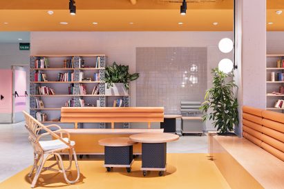 Yellow lounge space with wooden furniture by Masquespacio