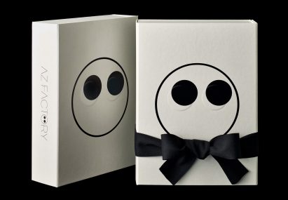 AZ Factory packaging with bow tie and an embossed face motif