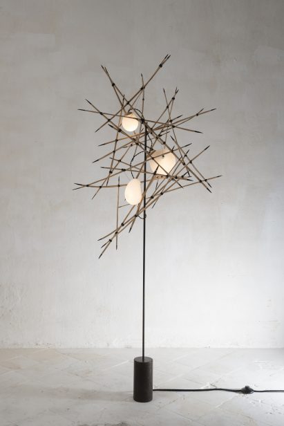 A floor lamp that looks like handfuls of matchsticks