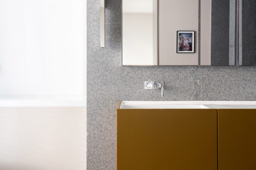 Walls are clad with grey terrazzo