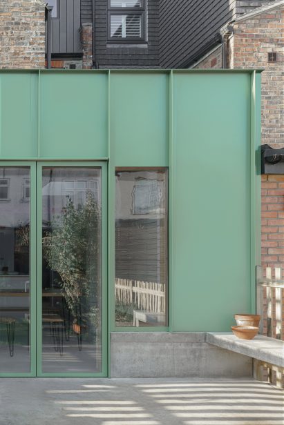 The green aluminium-clad facade of an extension by DeDraft