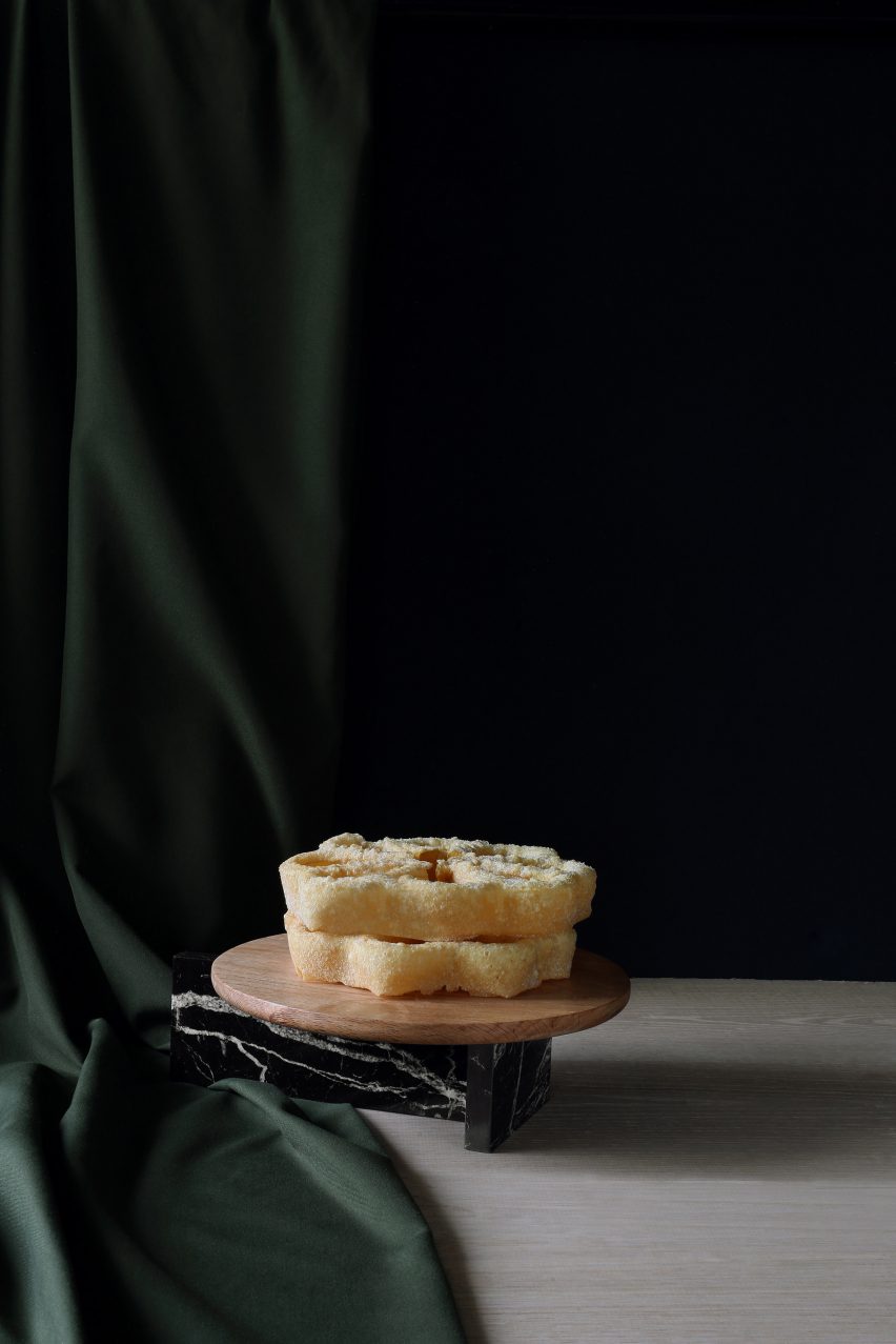 A wooden and marble platter with cake on top