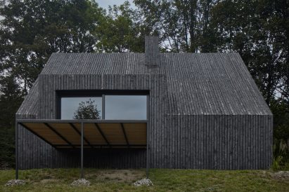 Wooden house with large sliding doors leading to a terrace