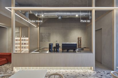 Wooden coffee bar counter with concrete base and floor lighting