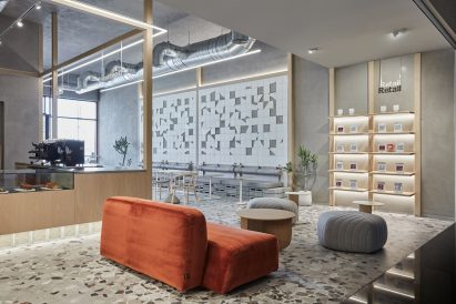 Broken ceramic wall and terrazzo floor with red sofa in cafe