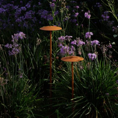 Two outdoor lamps by Marset hidden within greenery