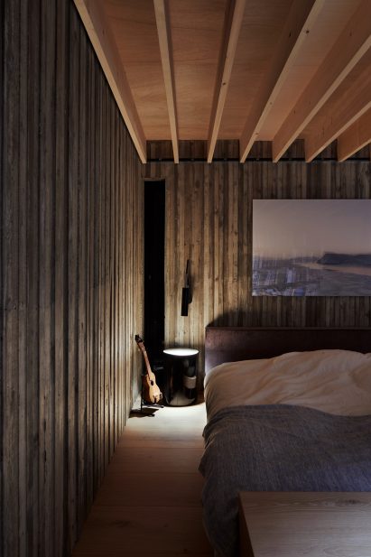 A dark timber-lined bedroom