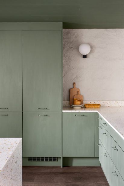 Kitchen with countertops of terrazzo flecked with orange stone