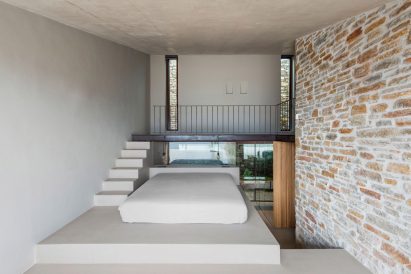 Split level bedroom features a platform bed and mezzanine