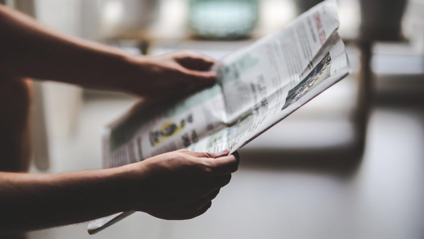 Man holding a newspaper to illustrate opinion about architecture critics