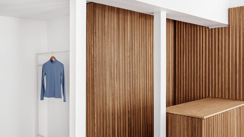 Wooden counter and white clothing rails in the OCE Copenhagen store interior by Aspekt Office