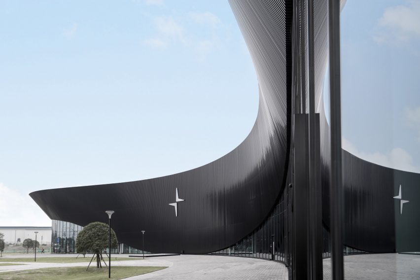 A curved black facade of a car factory