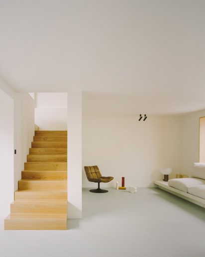 A wooden staircase in the living room of a Parisian townhouse