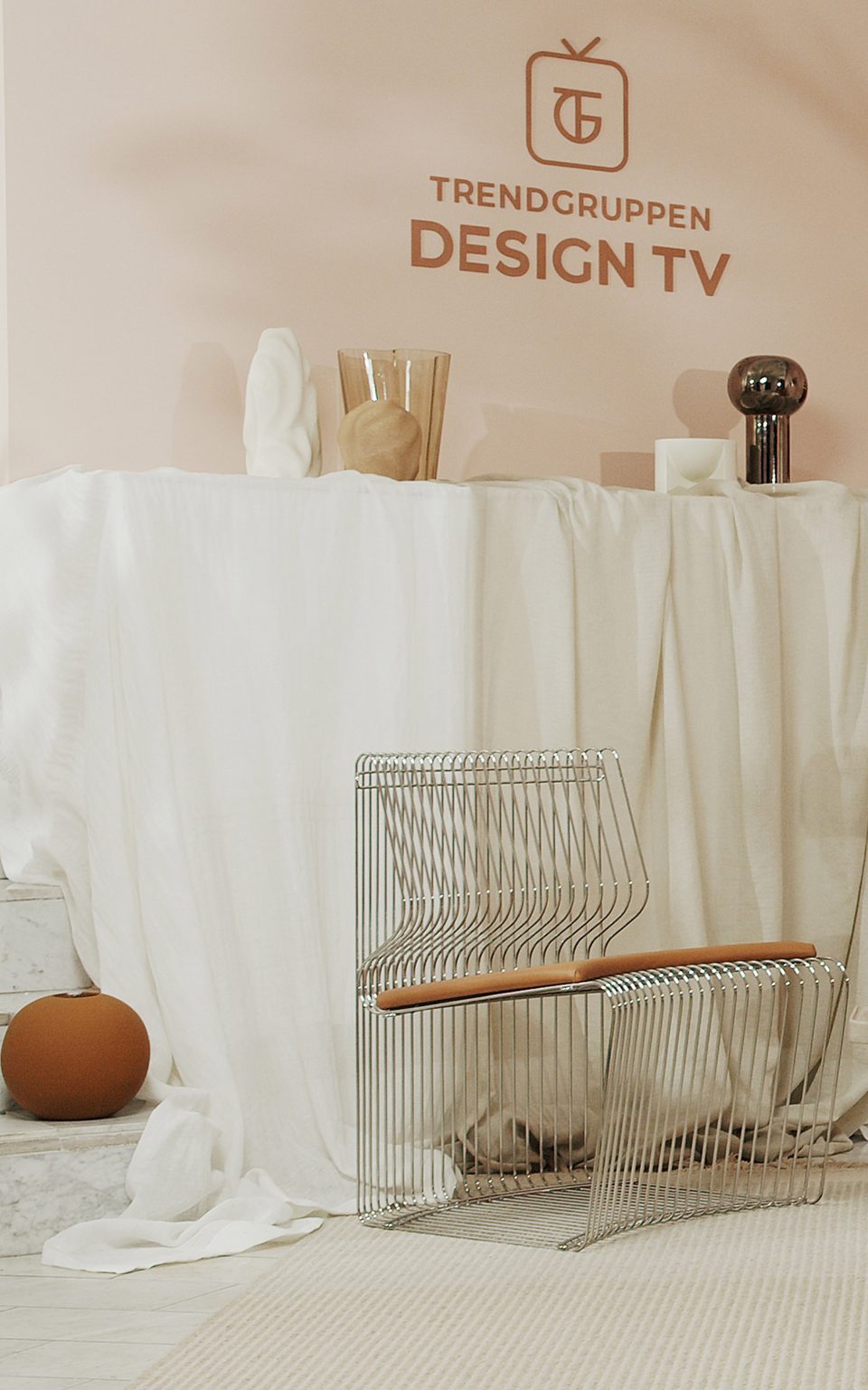 A steel chair and glass and ceramic vases on TV set