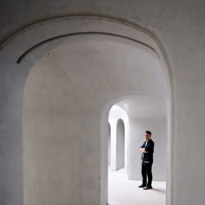 Portrait of Ma Yansong in a white-concrete building