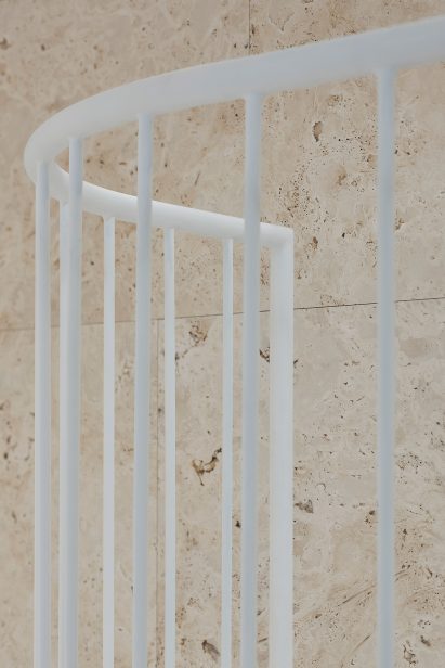 Travertine wall and steel staircase banister in Vilnius apartment by 2XJ