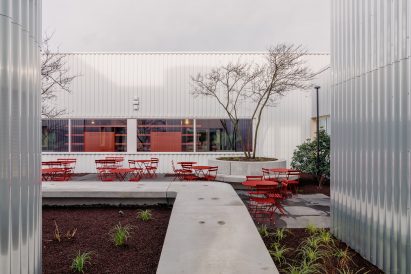 The courtyard has red furniture and wild landscaping by Studio Anton Hendrik Denys
