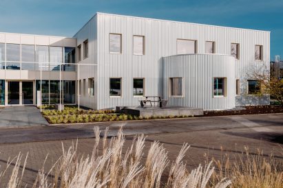 The building has a modular form and is clad in corrugated aluminium