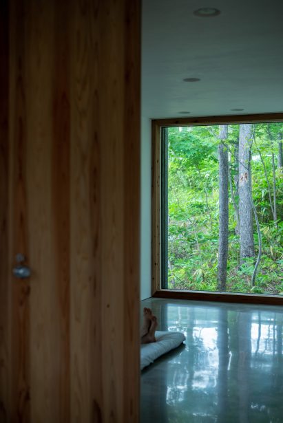 Floor to ceiling windows look out to the forest by Florian Busch