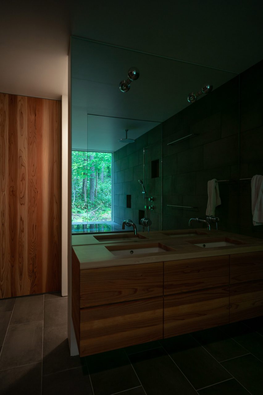 The bathroom uses wood finishes