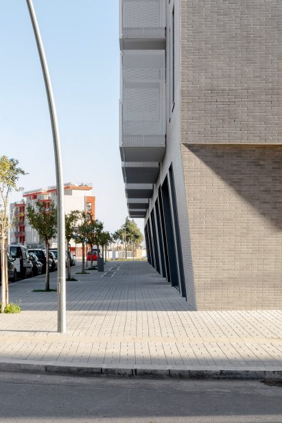 Protruding balconies hang over the street by Alvisi Kirimoto