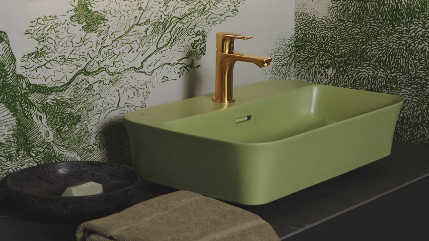 A bathroom with a sage green sink and brass tap