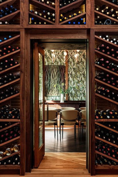 Wall of wine racks and botanical wallpaper in Peacock restaurank
