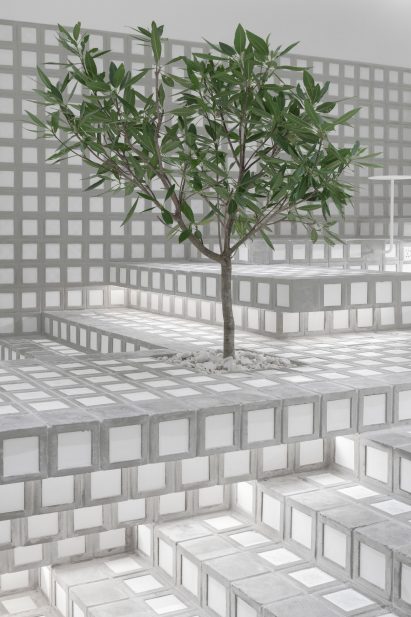 Tree integrated into seating landscape in cafe interior by Precht