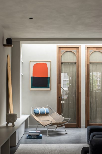 Lounge with clay walls and arched wooden doorframes Amsterdam garage conversion