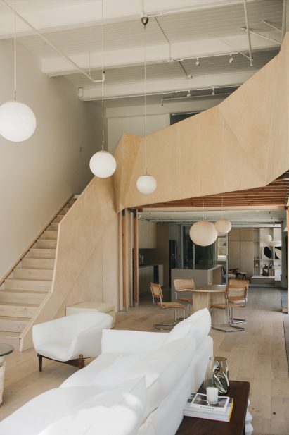 Sculptural wooden staircase and mezzanine by OWIU Studio