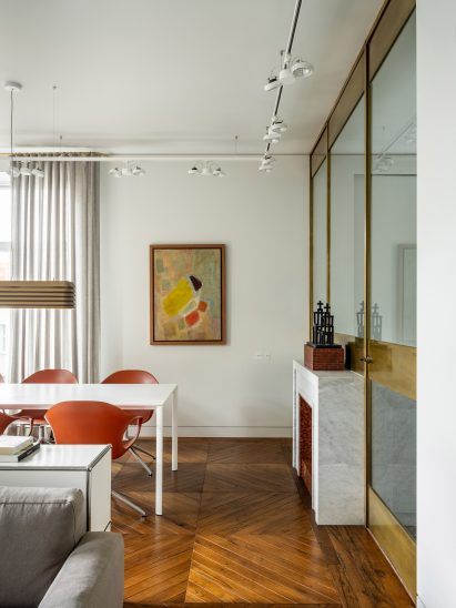 Dining room and brass-framed glass partition wall in Moscow apartment