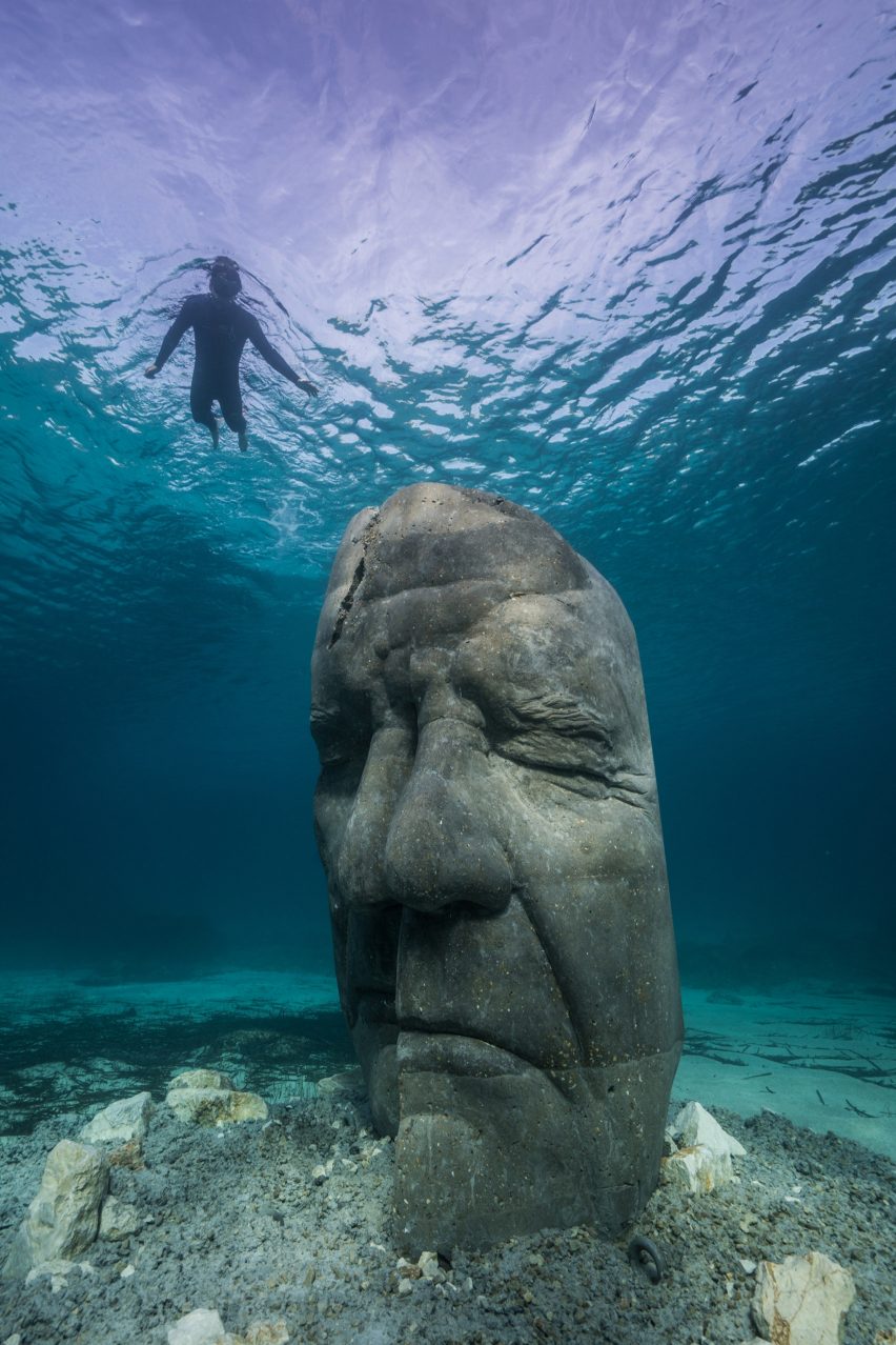 A snorkelers observing an underwater sculpture
