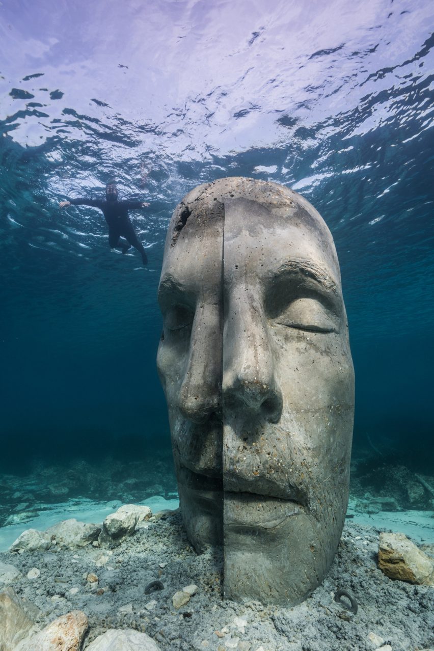 A snorkelers observing an underwater sculpture