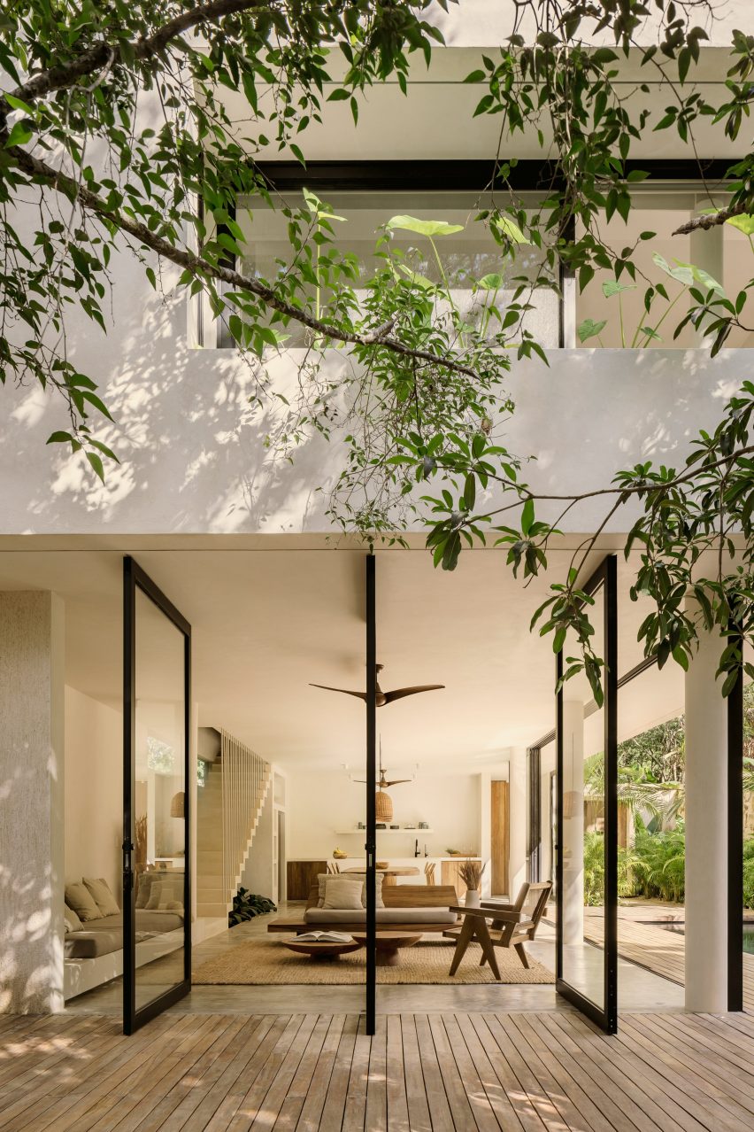 The house's large windows blend interior and exterior spaces