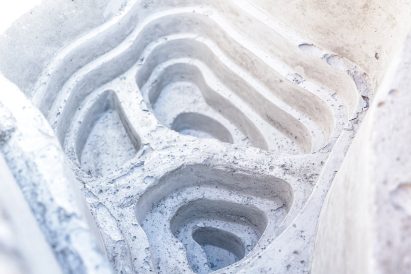 The textured and layered interior of a man-made rock pool by Econcrete
