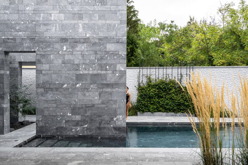 A swimming pool outside a private stone spa