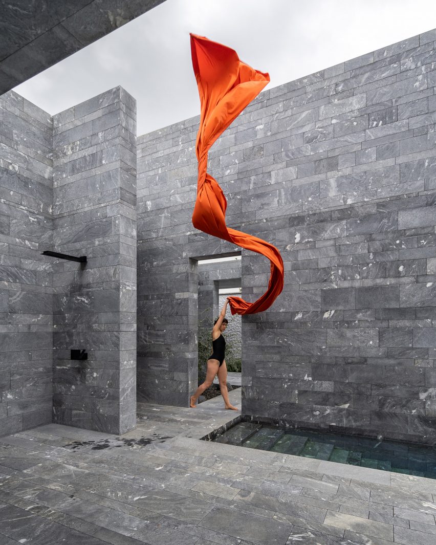 A model outside the stone exterior of a private spa in Austria