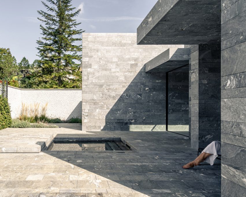 The exterior of a monolithic stone spa by Smartvoll