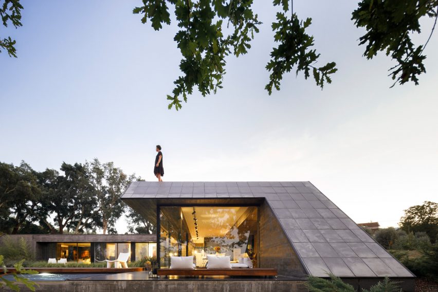 An angular concrete house with a roof terrace