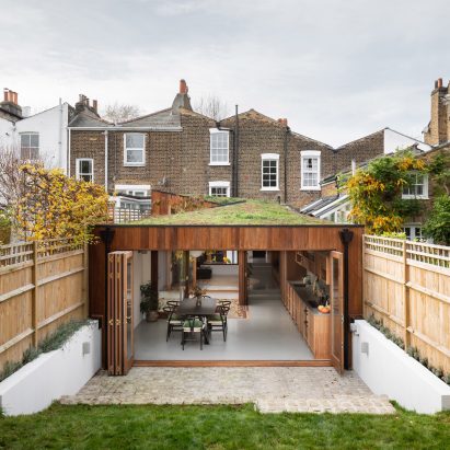 A wood-clad house extension with a green roof
