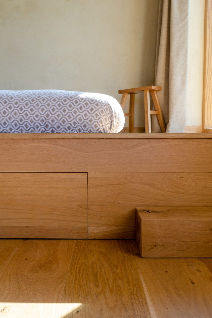 The raised bed of a wooden cabin by Out of the Valley