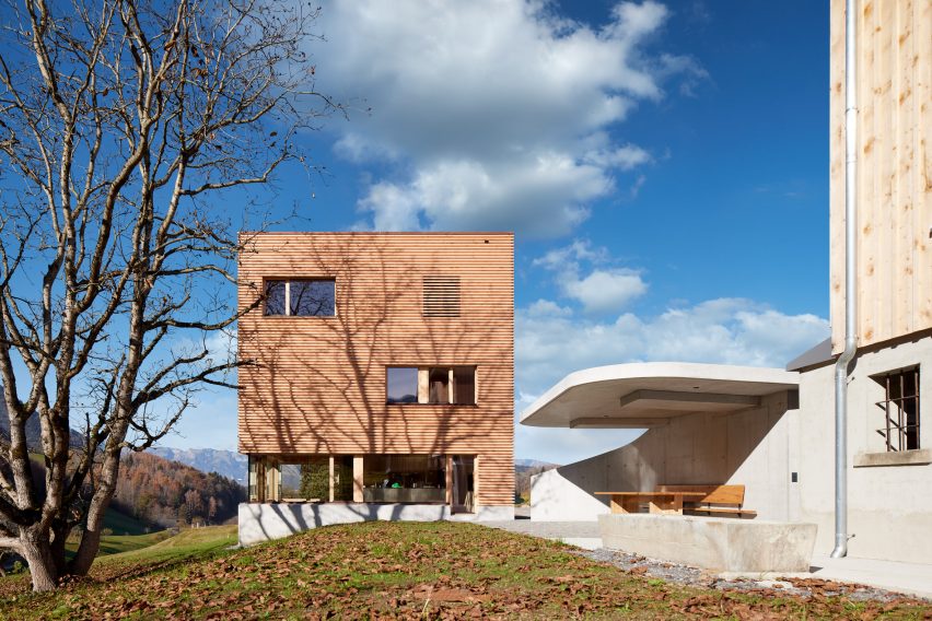 A square timber-clad house and concrete carport