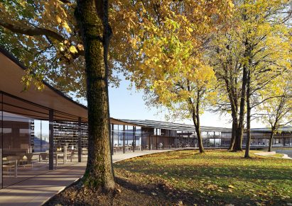 A wooden building that curves around trees