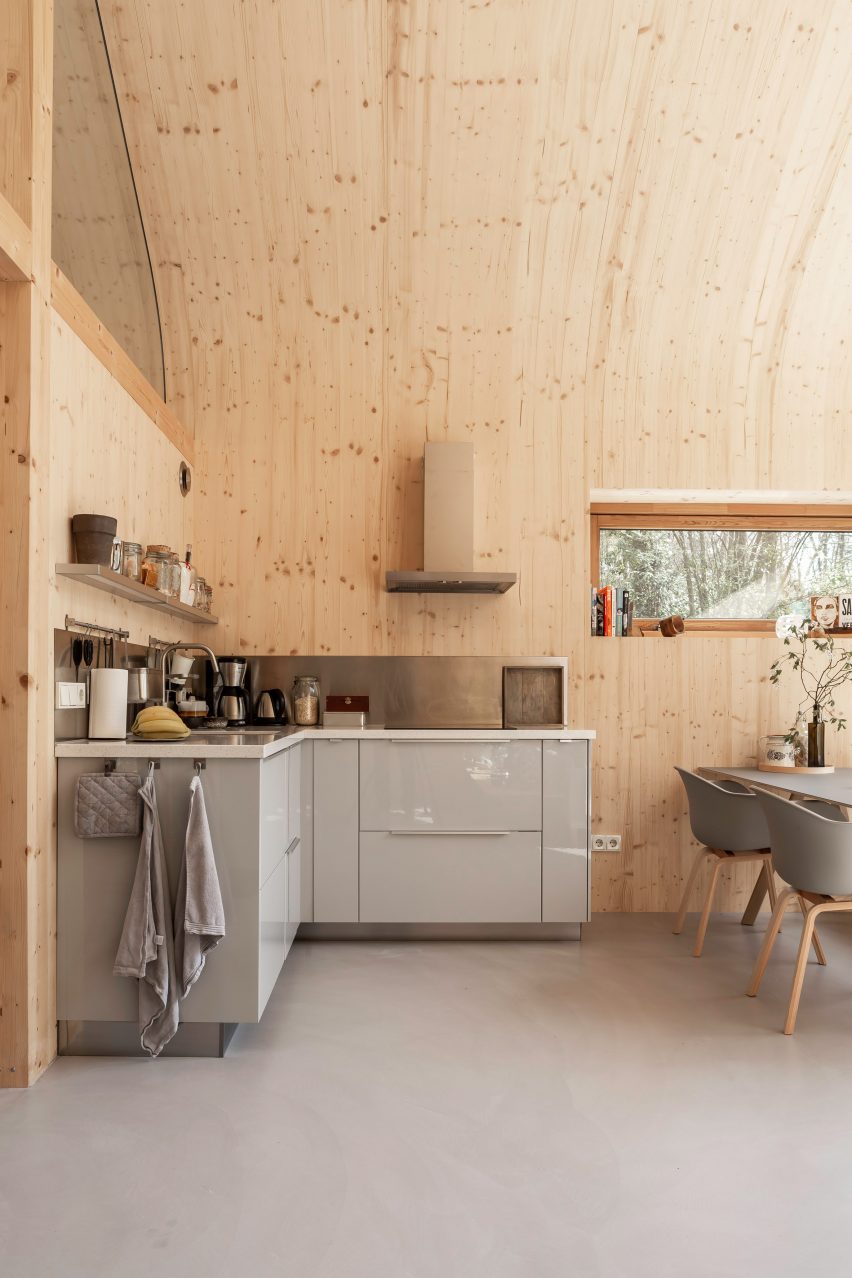 Grey kitchen units against wood-lined walls