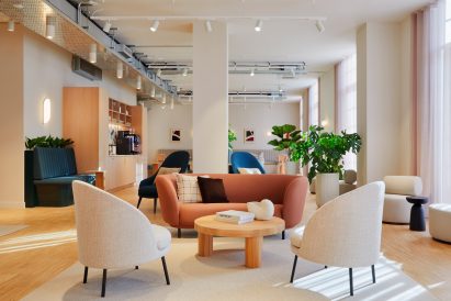Terracotta sofa and white chairs on white carpet